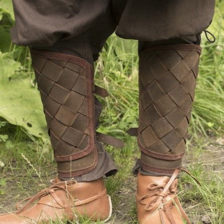 Brown woven leather Pirate greaves with brass buckles, protecting calves over boots.
