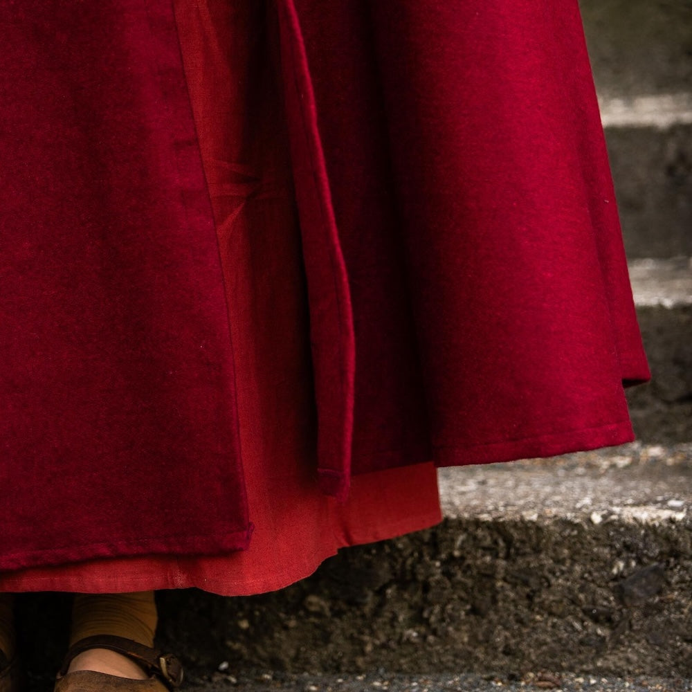 Close-up of the metal clasp on the red wool cloak