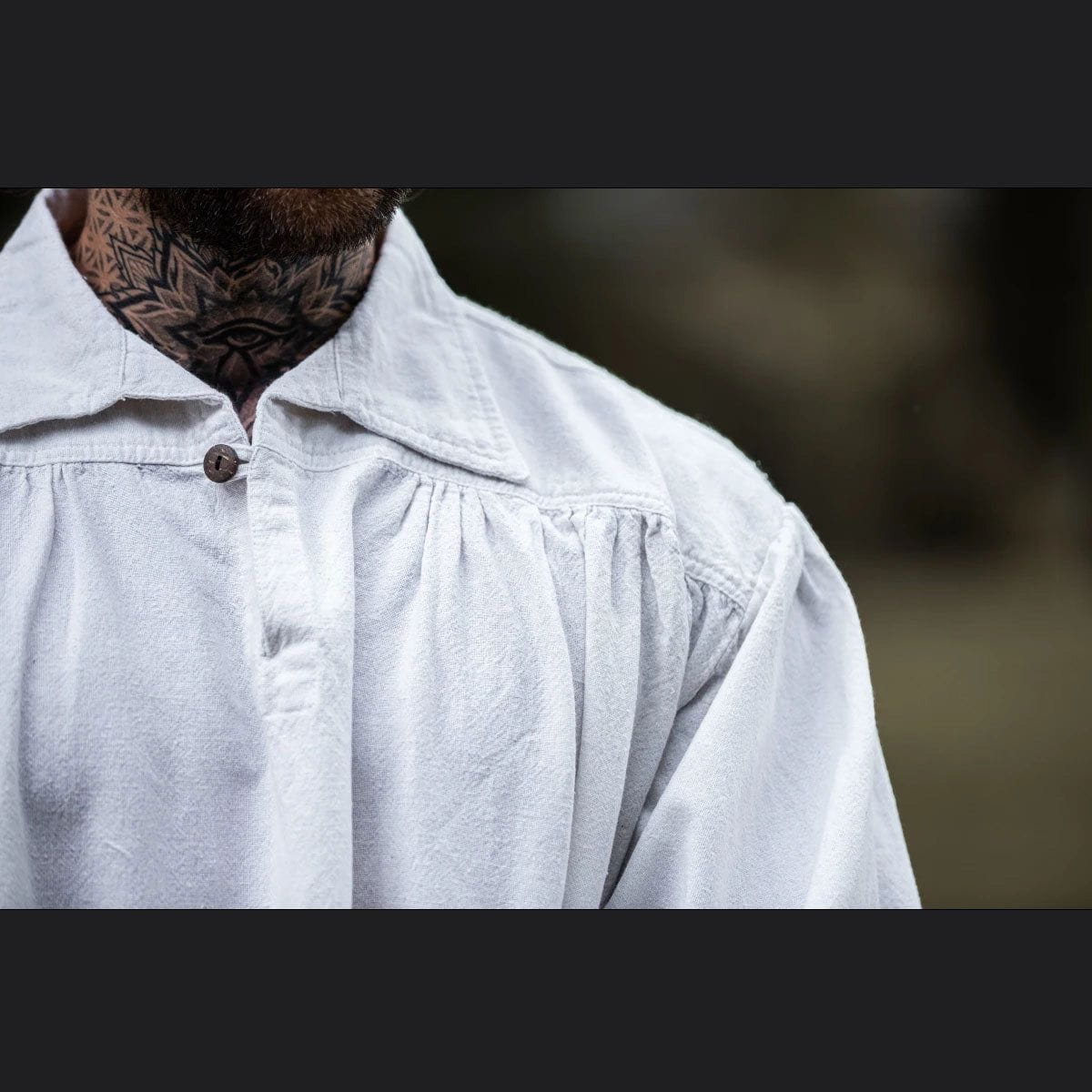 White cotton Pirate shirt with V-neck, collar, and wooden button.